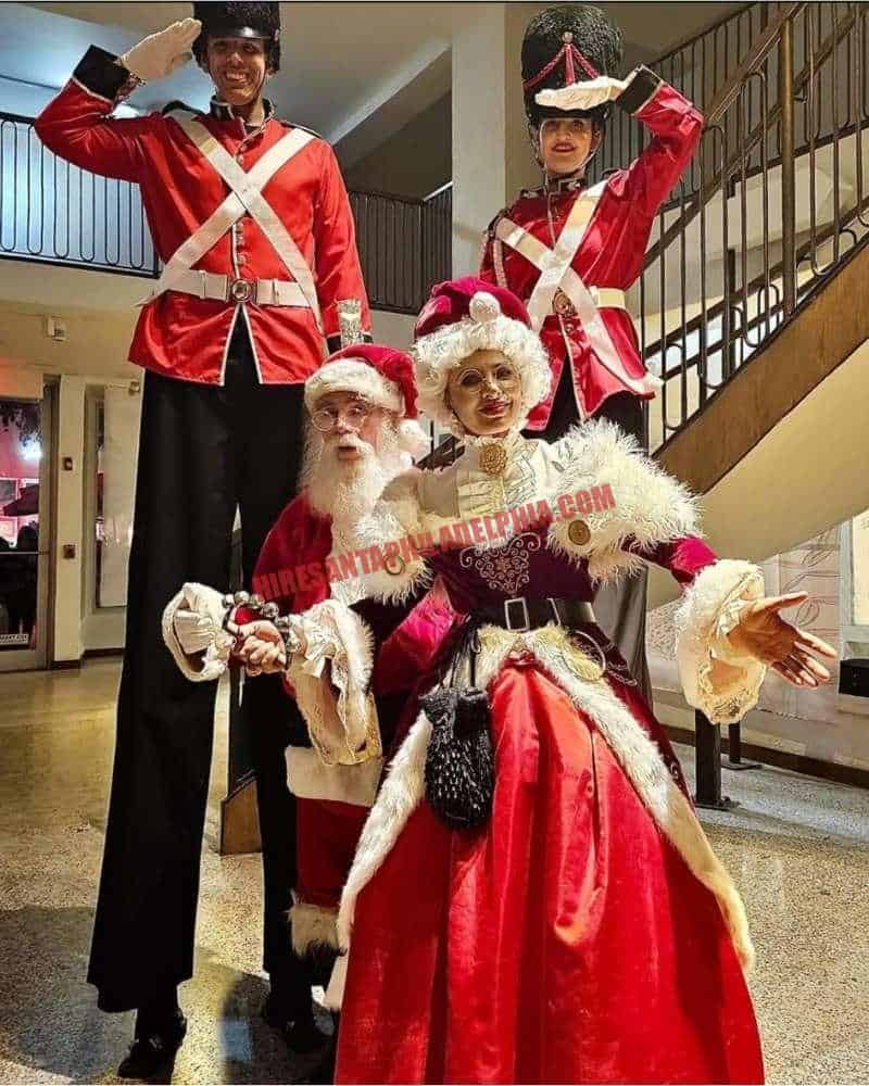 Santa for an office party in Philadelphia: two stilt nutcracker soldiers with Santa and Mrs. Claus indoors.