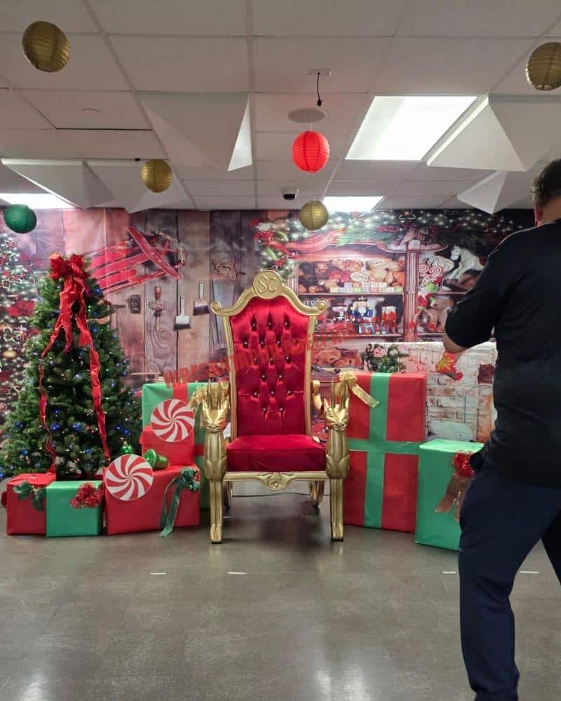 Santa photo session in Philadelphia: empty gold chair among gift boxes and a lit tree.