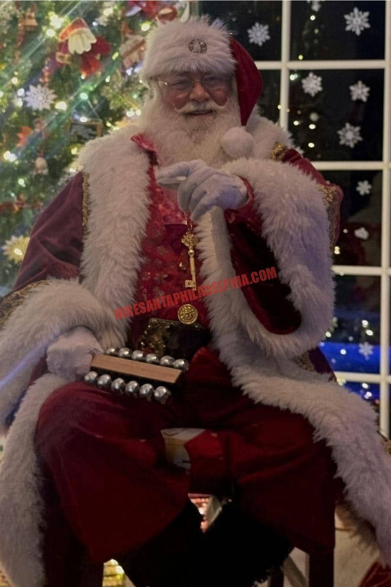 Santa for hire in Bucks County, PA with sleigh bells by a tree and a night window.